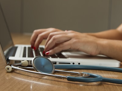 A laptop and stethoscope used during a healthcare consultation